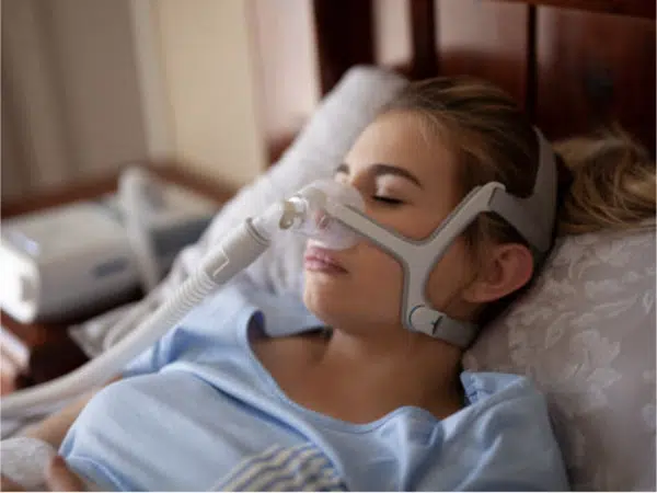 Paciente usando CPAP para dormir melhora a apneia e o sono.
